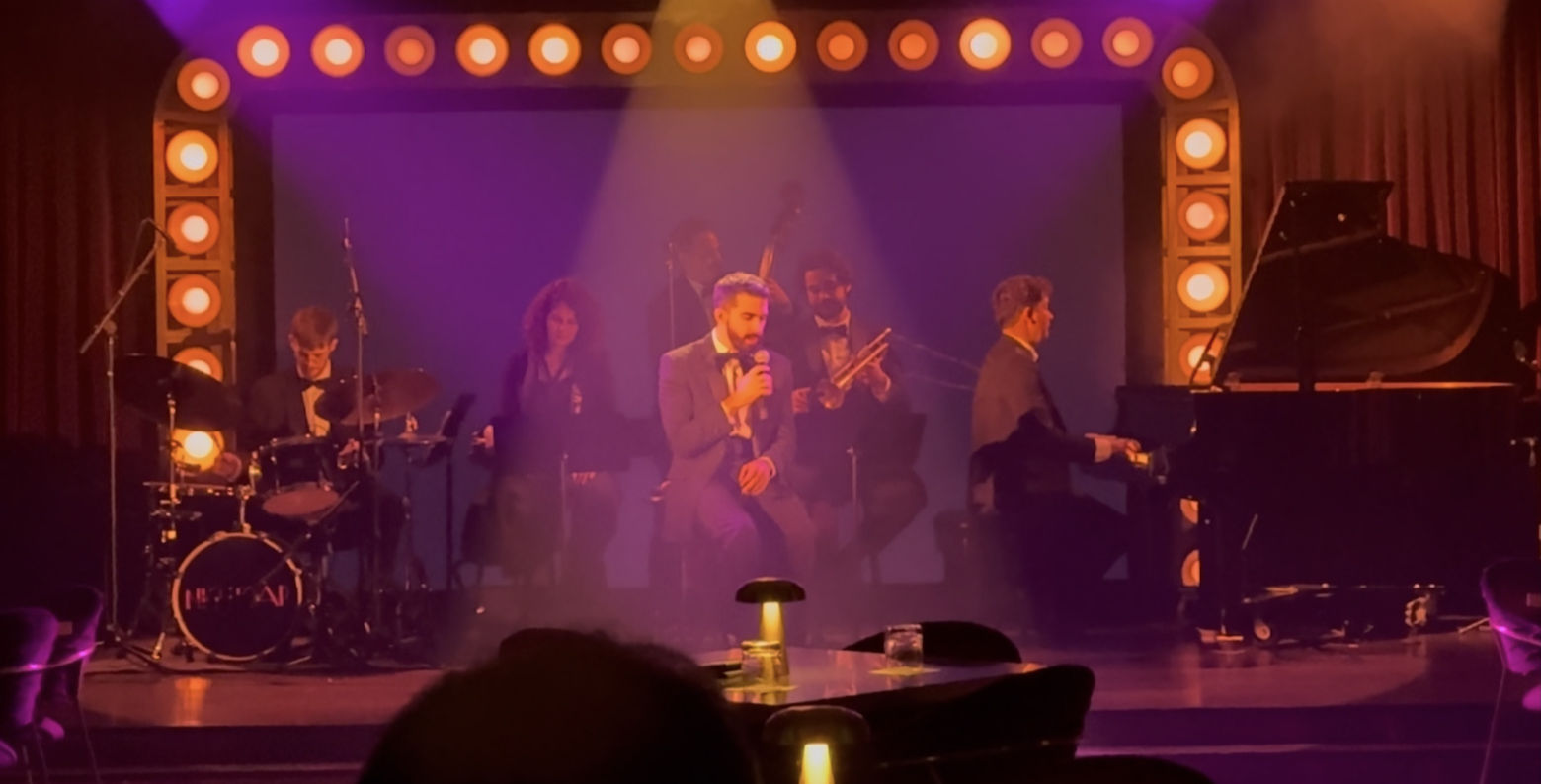 Alec Funiciello performing with his full band under stage lights